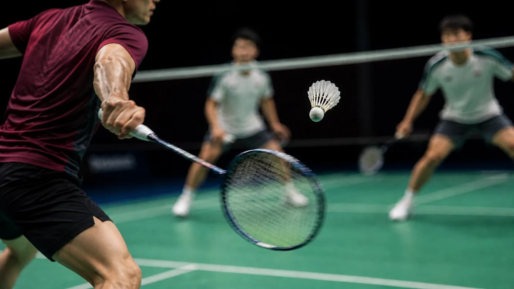 Badminton players contesting a fast rally on an indoor court